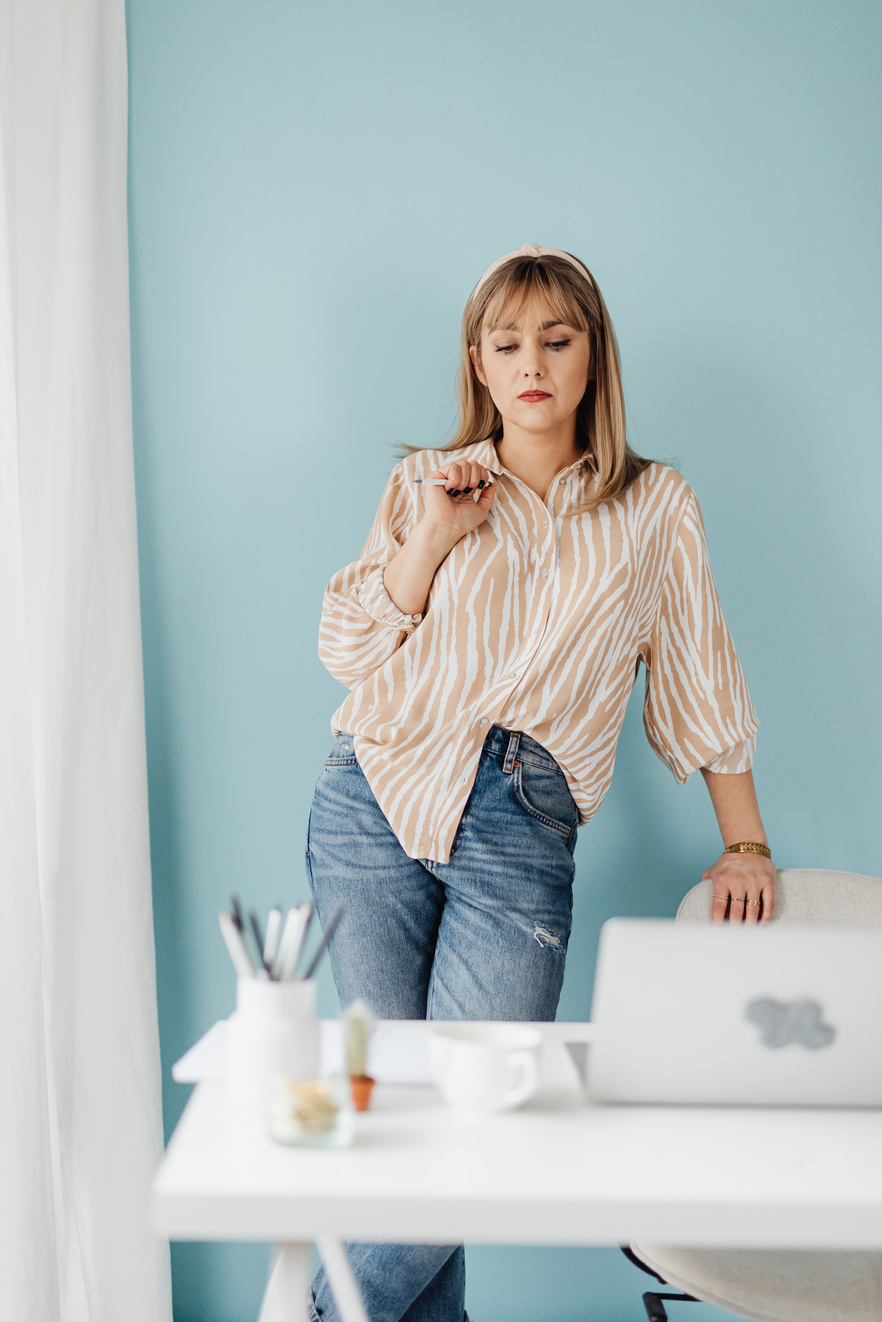 A Woman Standing at the Table Holding a Pen