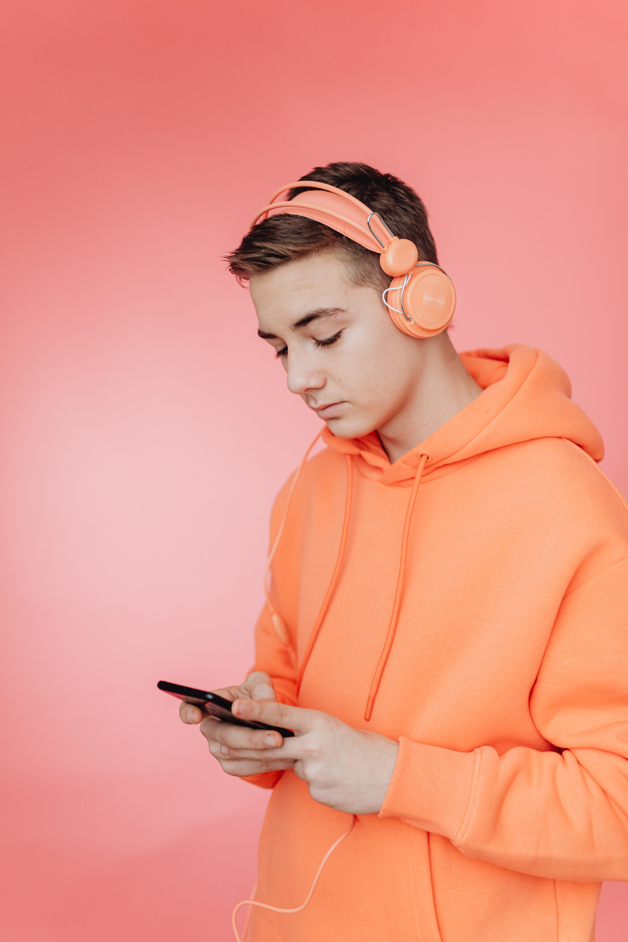 A Man Wearing Headphones while Using a Cellphone