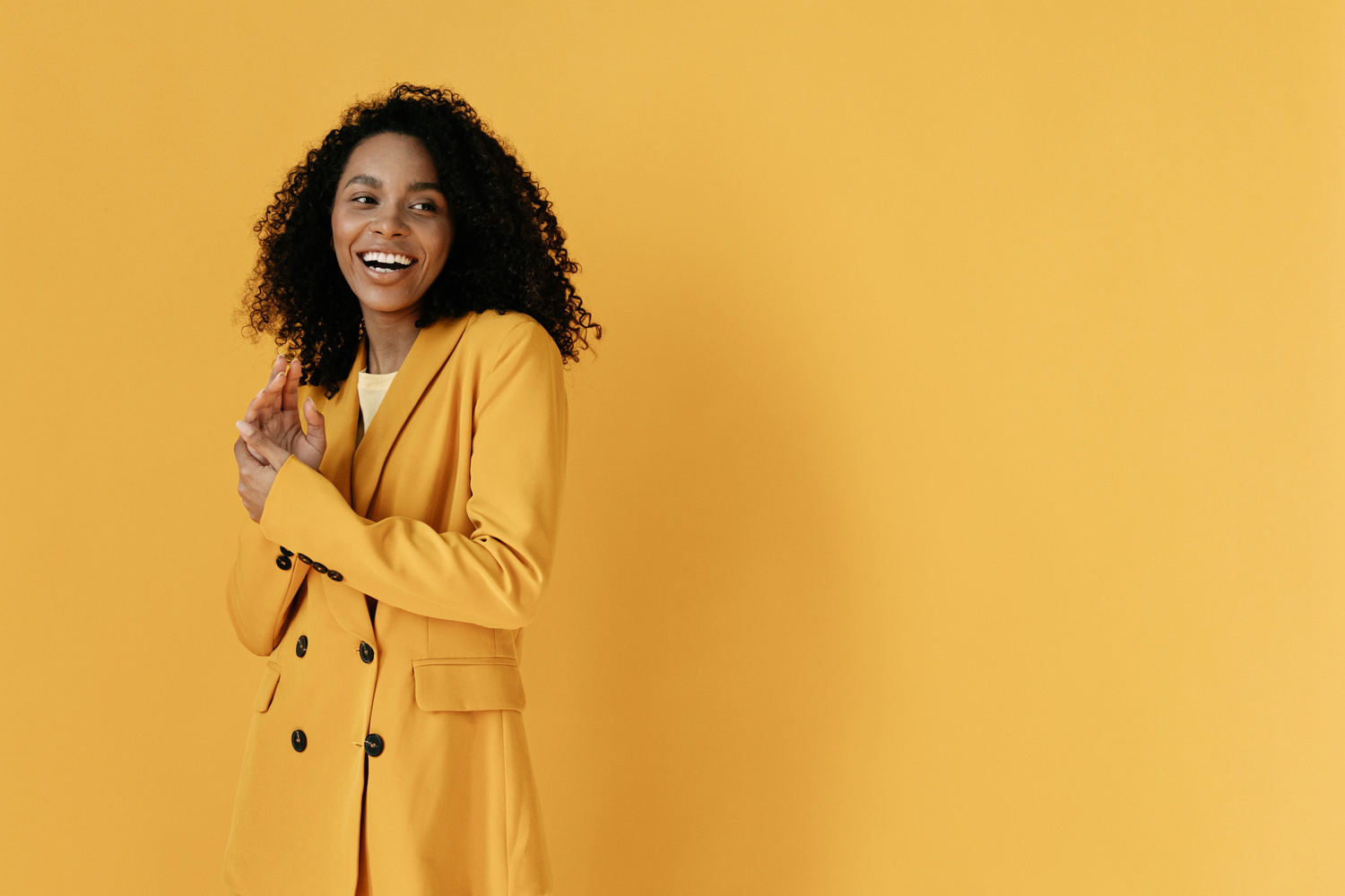 Woman in Yellow Coat Standing Near Yellow Wall